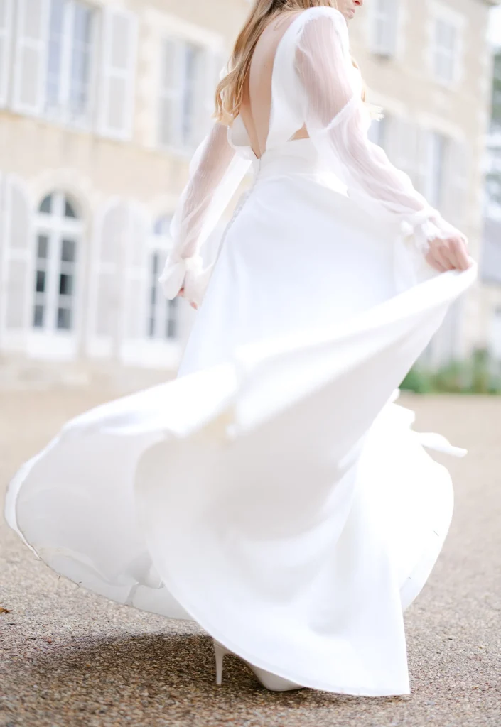 une mariée en mouvement qui danse et fait tourner sa robe de luxe